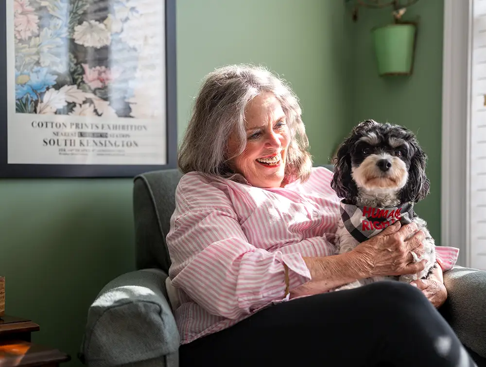 Senior woman holding her dog on her lap