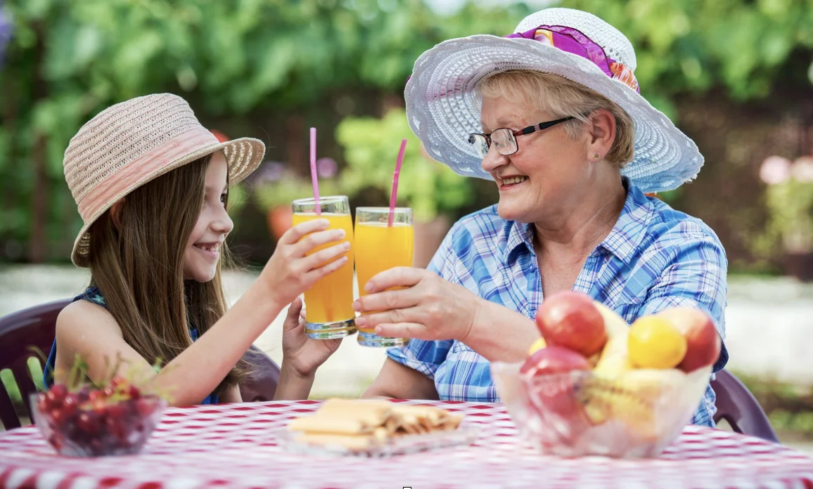 Senior woman enjoying juice with her grandchild